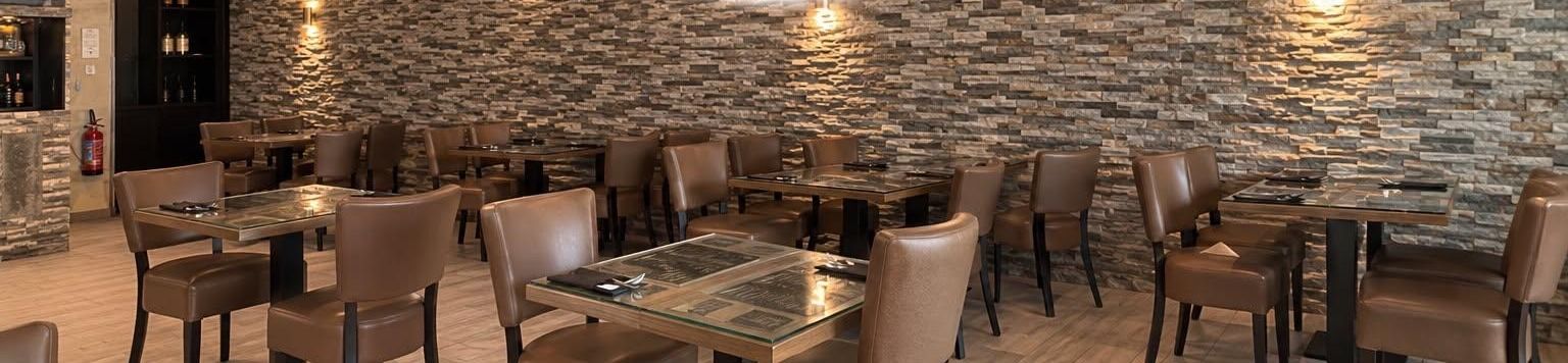 La grande salle de Sapori di Puglia, mur en pierre et tables dressées